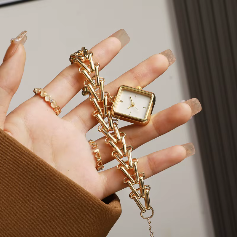 Montre de luxe dorée avec cadran triangulaire motif épi de blé
