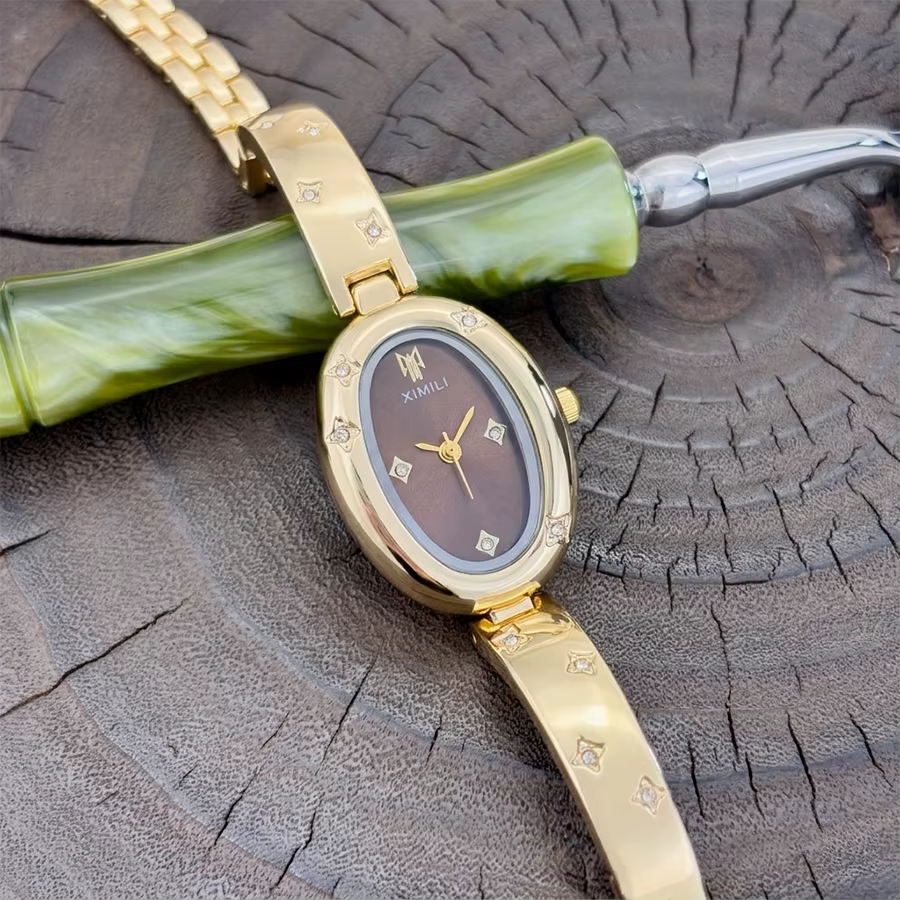 Montre ovale dorée tendance pour femme avec détail gravé en forme d'étoile : un accessoire intemporel