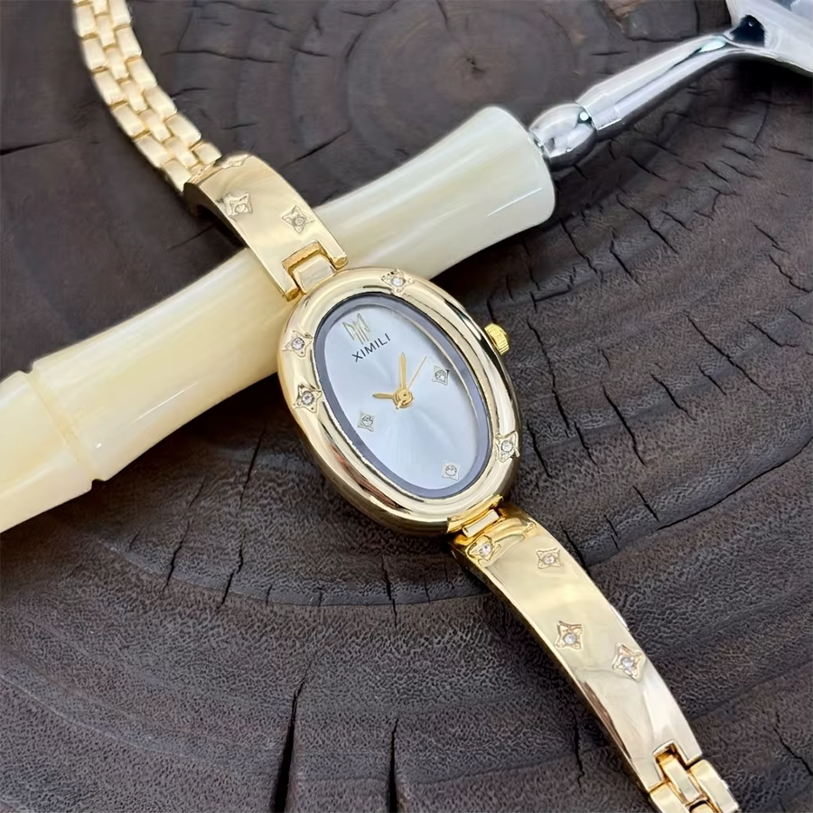 Montre ovale dorée tendance pour femme avec détail gravé en forme d'étoile : un accessoire intemporel